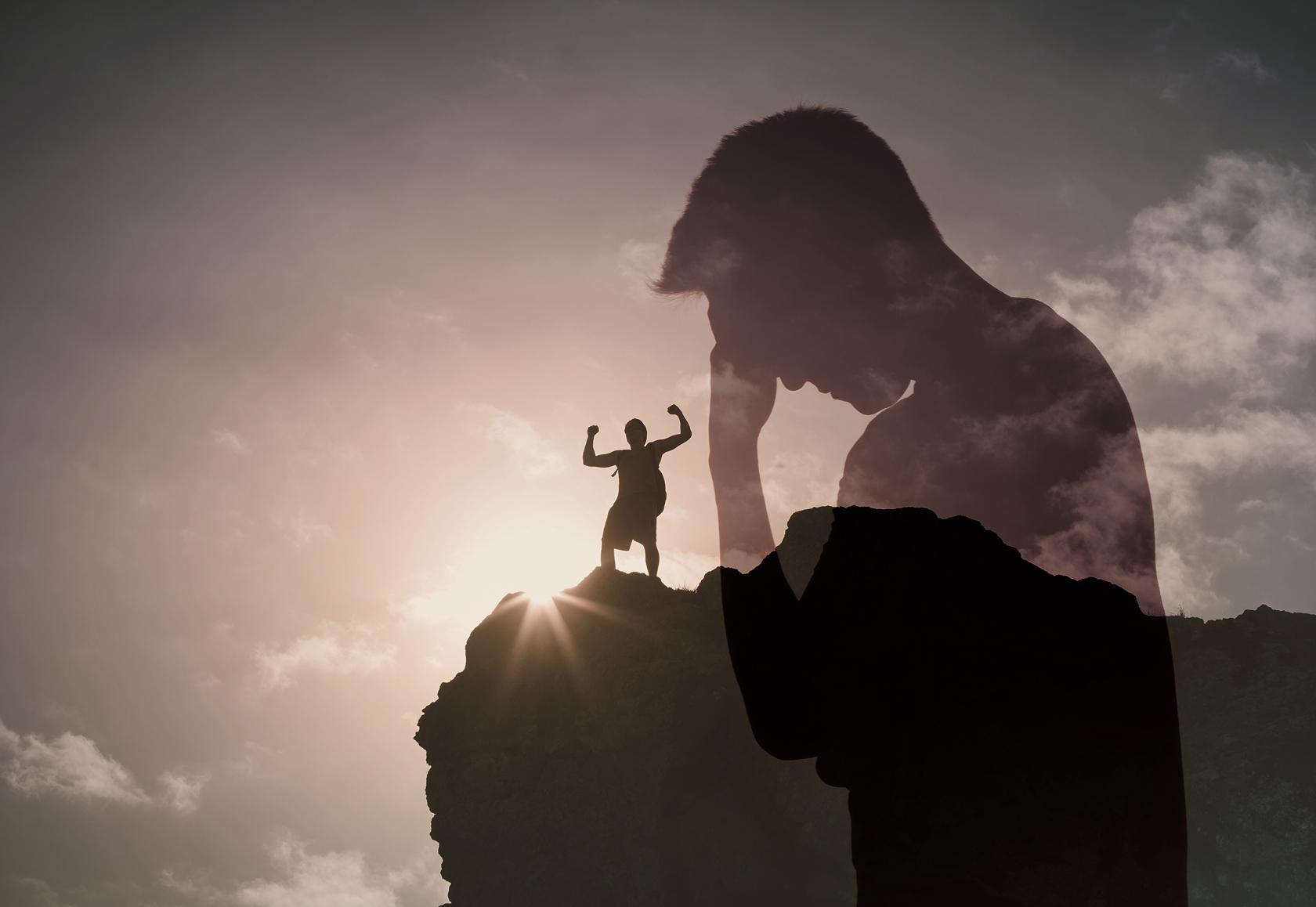 Silhouette of a small figure with raised arms standing on a rock, facing a large adult figure against a bright sky with clouds.